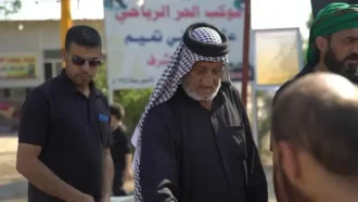 پیر خادم ابا عبد الله علیه السلام در حال پذیرایی از زوار با خرمای عراقی