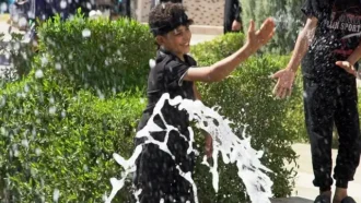 پسری در حال آب بازی با دوستانش
