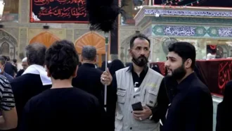 زوار در حرم و خدامی که در حال هدایت جمعیت هستند