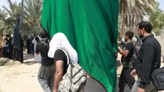 دو مرد که پرچم بزرگی را با هم حمل می کنند