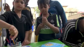 کودکان در غرفه نقاشی مشغول رنگ آمیزی