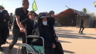 پیرزنی که با ویلچر به پیاده روی اربعین آمده