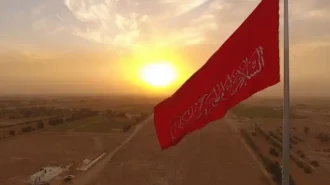 نمایی از پیاده روی زائران امام حسین (علیه السلام) و پرچم سرخ افراشته در مسیر