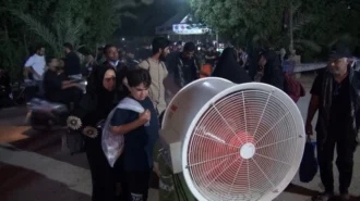 پنکه مه پاش و مردمی که برای خنک شدن جلوی آن می ایستند